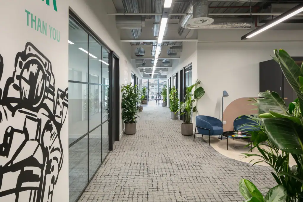 X+Why live plants lining workspace corridor