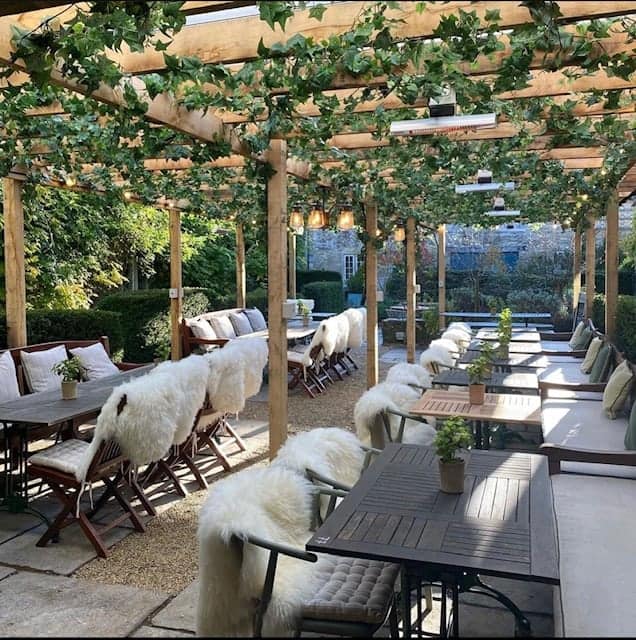 Installation in outside space at Butcombe Brewing Co sheltered by a timber pergola dressed with artificial Ivy garlands and plants in aged terracotta pots