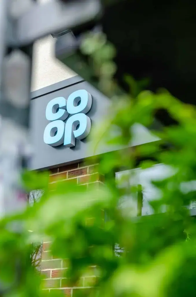 Co-op logo featuring its new living wall by I Want Plants in the foreground