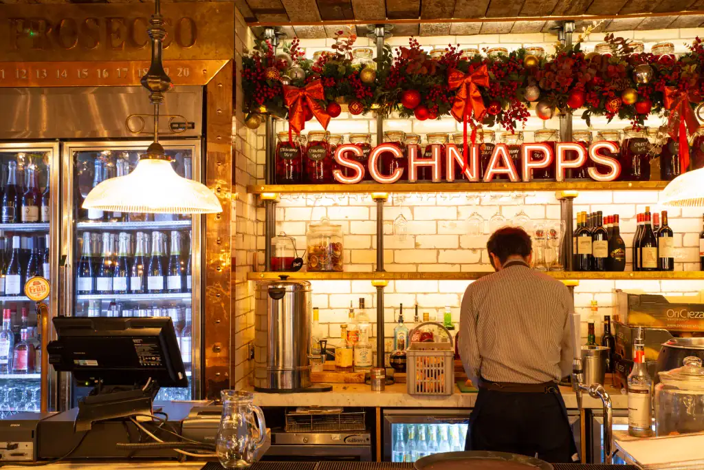 Christmas garland with red and gold coloured decorations fixed to bar in alberts schloss manchester