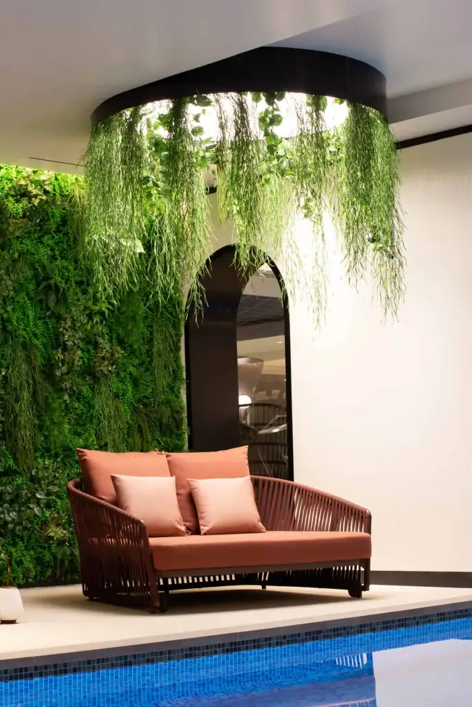 Green wall and hanging plant display in a pool area