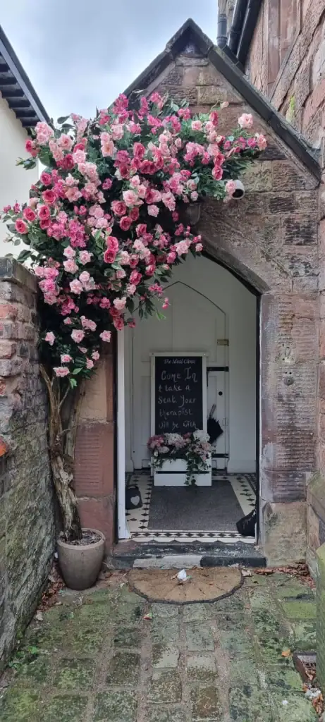 Artificial rose blossom tree curving around entrance door