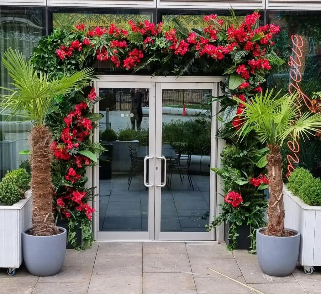 Artificial tropical themed floral display around restaurant entrance
