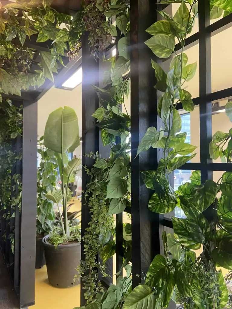Mix of live freestanding pot plants and artificial trellis planting at Peak A.I.