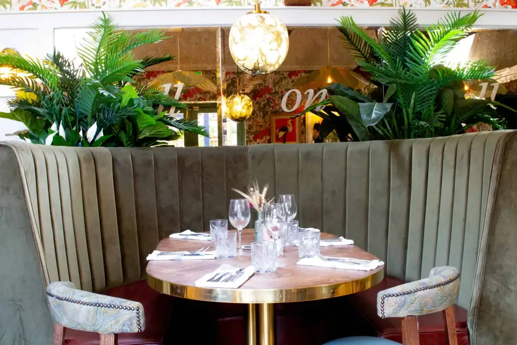 Circular booth seating with artificial plants built in above by I Want Plants