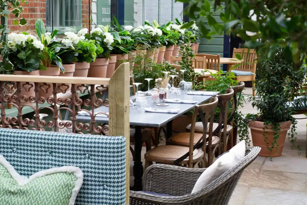 Artificial white geraniums in terracotta pots at The Bull Henley external terrace area by I Want Plants