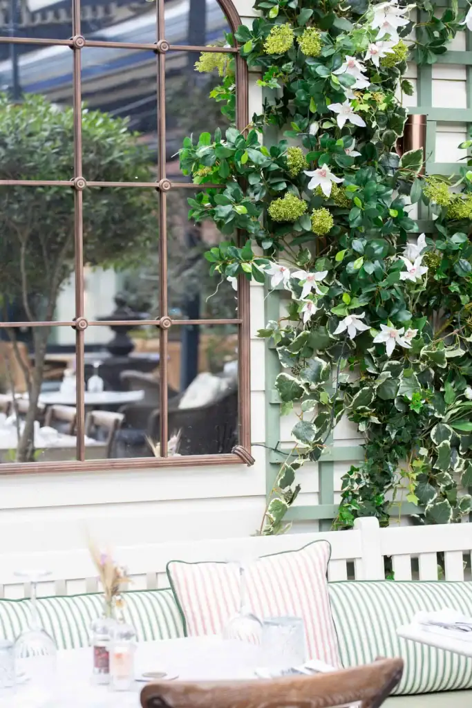 The Bull Henley outside terrace with mirror next to artificial foliage attached to trellis