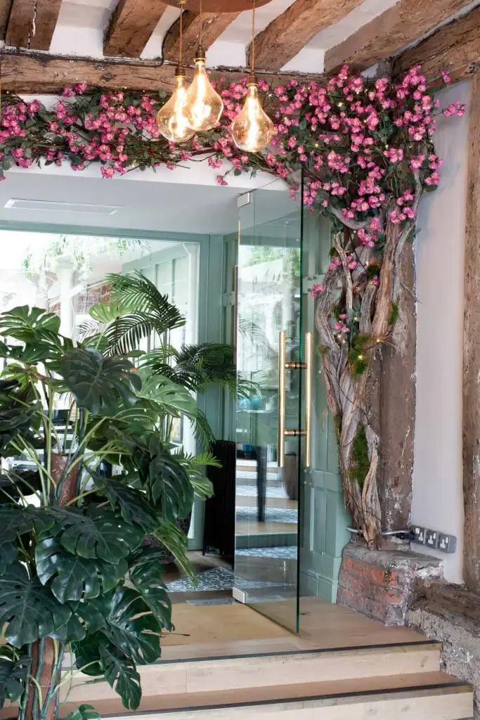 Custom made rose blossom tree with branches growing along ceiling at The Bull Henley by I want plants