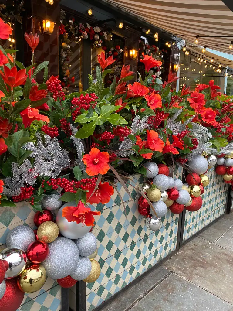 Flight club planters with artificial red flowers, berries and red gold and silver baubles