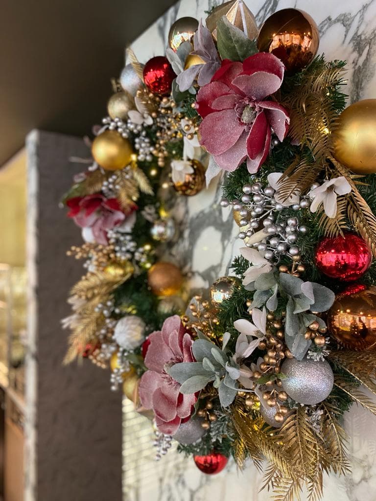 Festive wreath decorated with gold and silver berries, frosted flowers, gold foliage and red gold and silver baubles by I want plants
