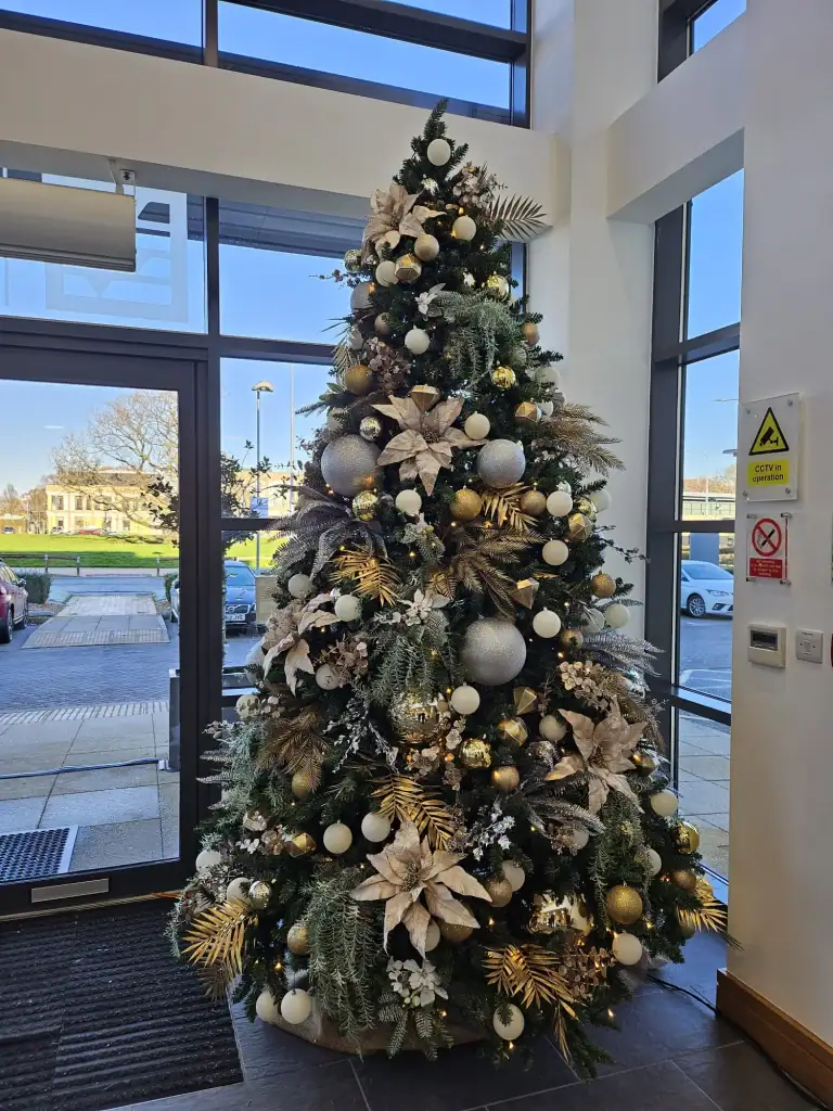 Gold and silver decorations artificial christmas tree in company entrance by I want Plants