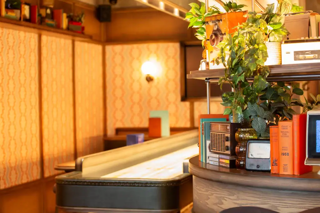 Small artificial trailing plants in posts on shelves at Electric shuffle manchester