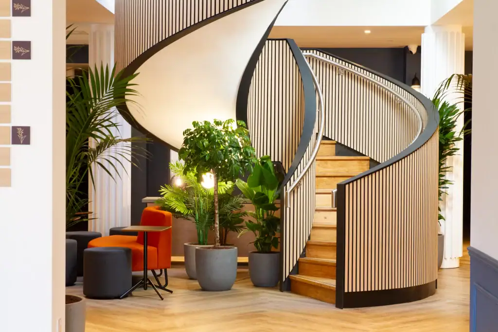 An office space using hire plants to frame a staircase with greenery.