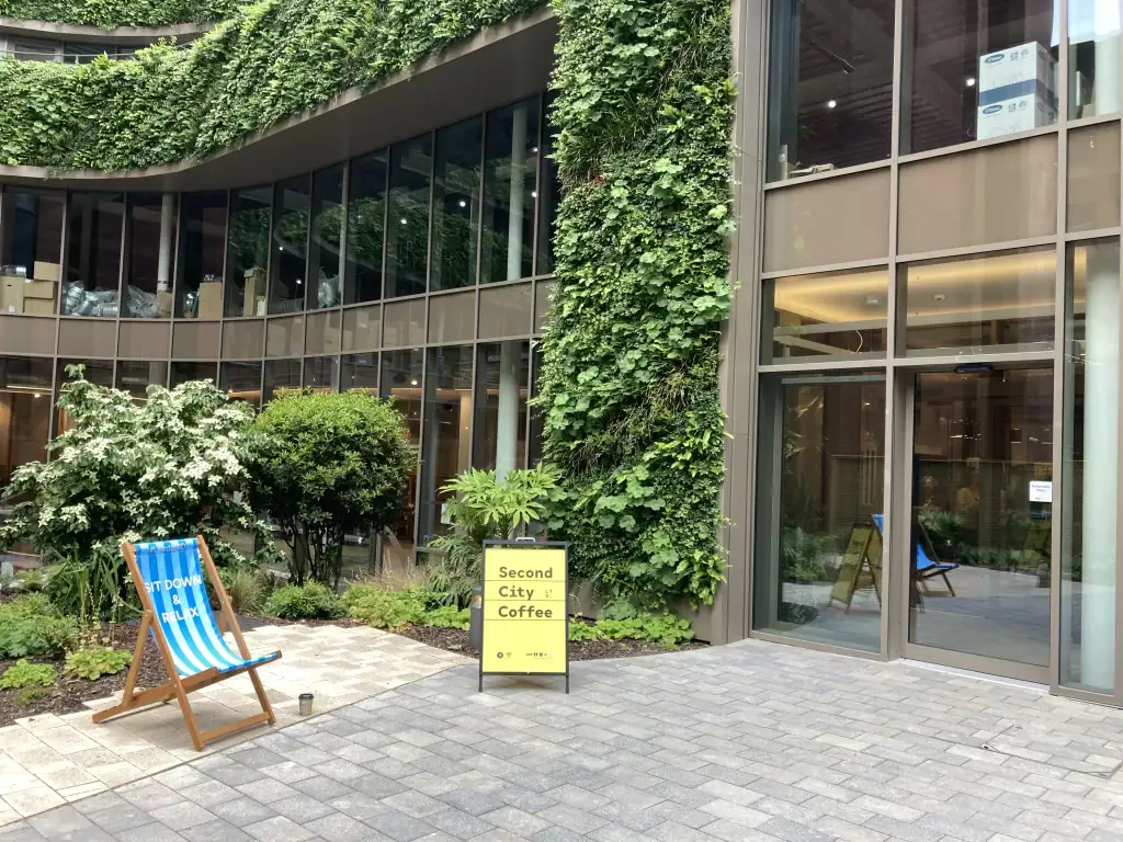 West Village with coffee a-board next to HYVERT living wall
