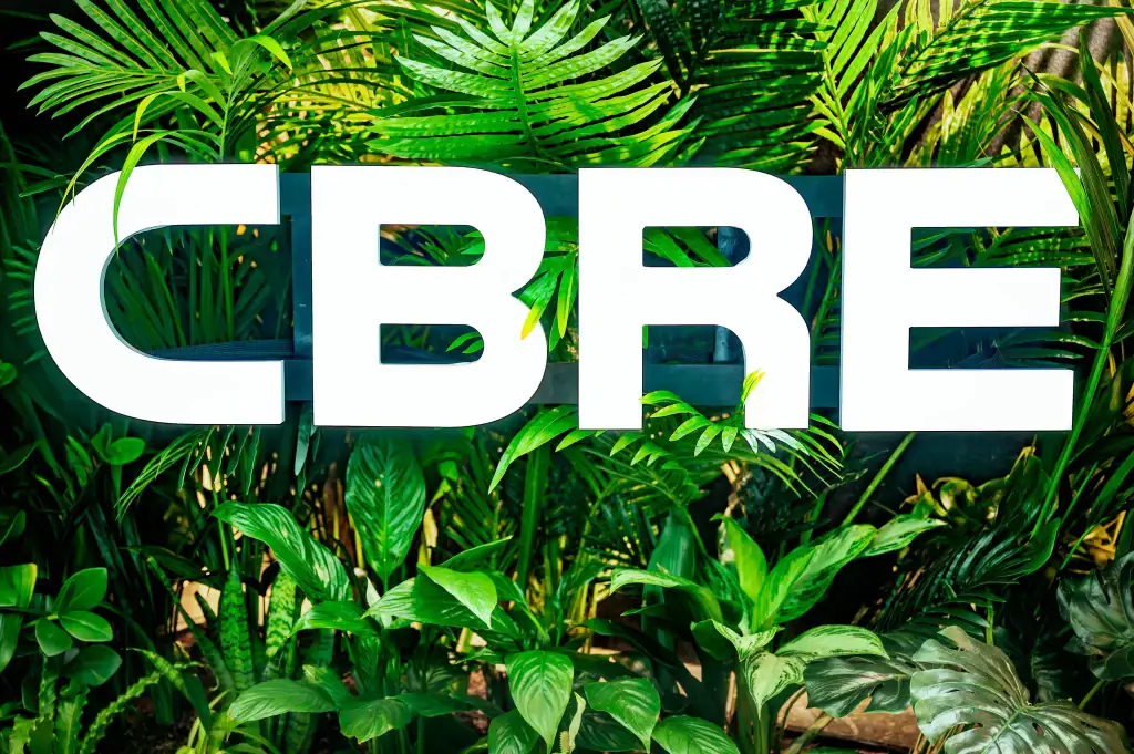 CBRE logo with artificial plant display by I want plants behind
