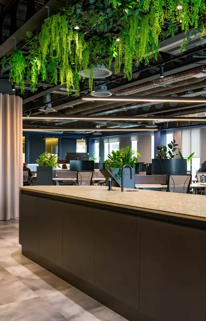 Hanging artificial plants above communal workspace island