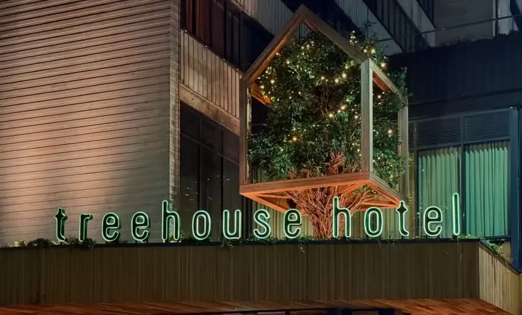 Treehouse Hotel Manchester signage at night time